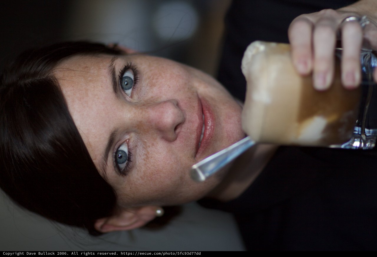Blue-Eyed Woman Savoring an Iced Coffee Drink