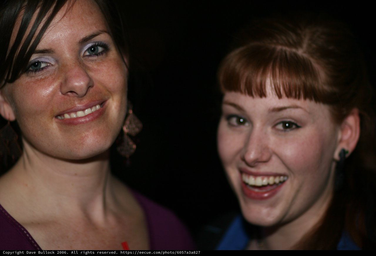 Two Friends Laughing Together at a Nighttime Event