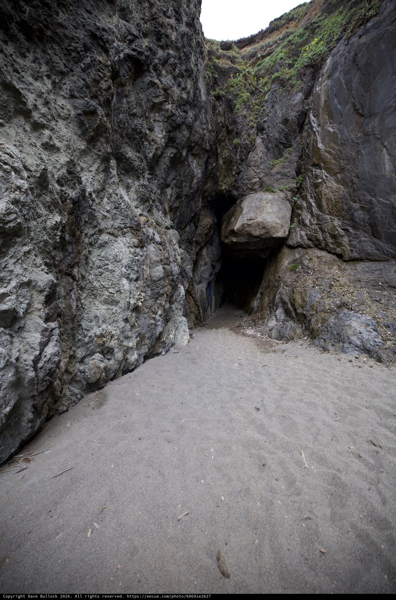 Dark Cave Entrance in Coastal Rock Cliffs