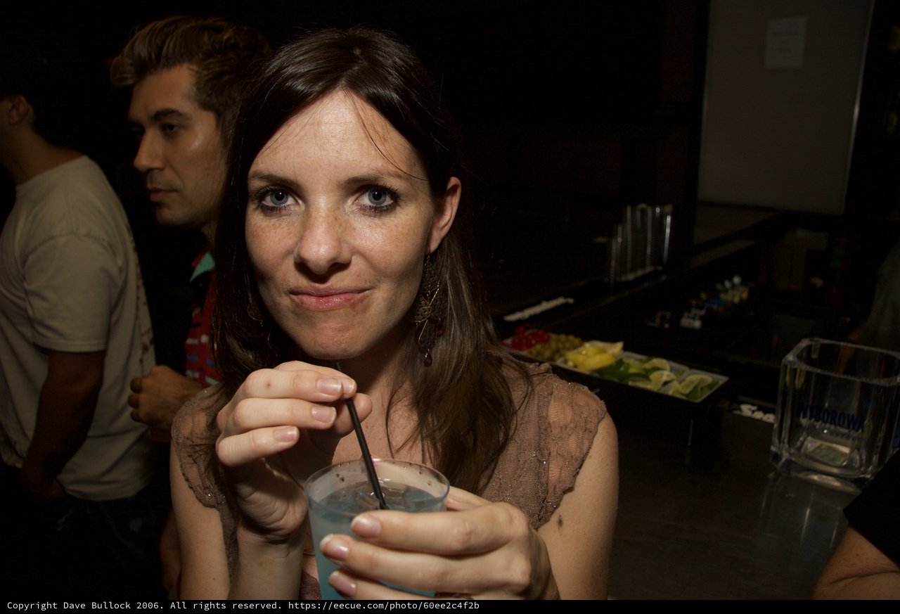 Woman at Bar Smiling with Cocktail Drink