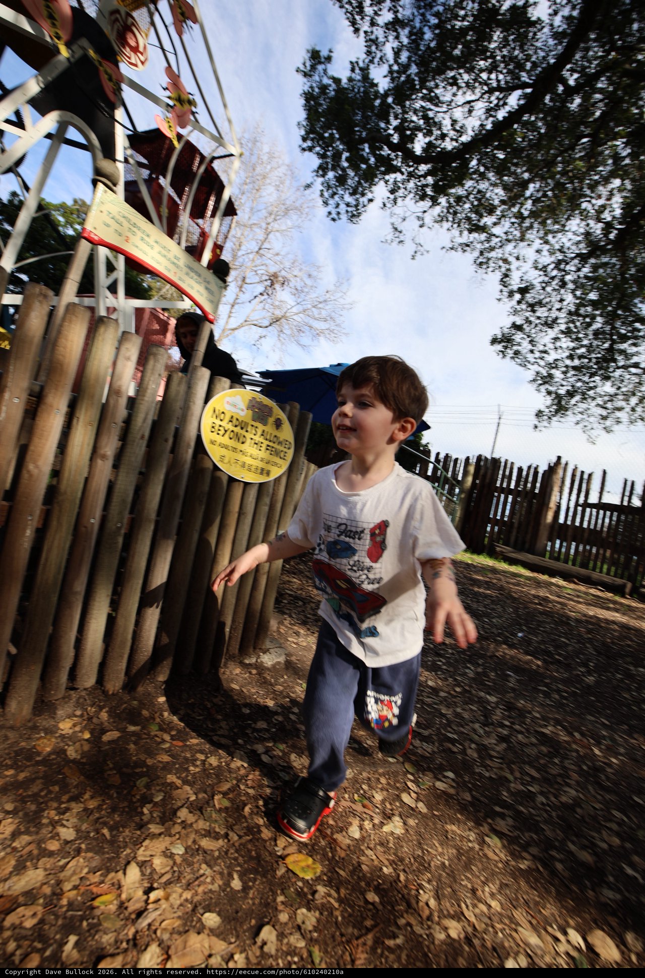 Young Boy Running Through Playground on Autumn Day