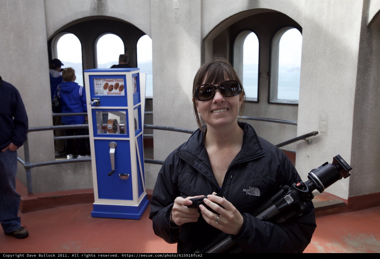 Photographer Smiling at Pressed Penny Souvenir Machine