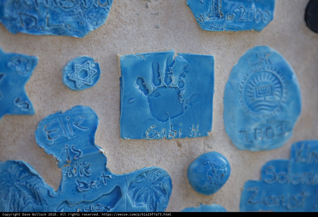 Blue handprints and symbols on ceramic tiles