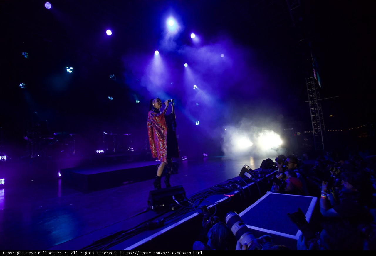 FKA twigs Wide Stage Blue Purple Lighting Red Brocade Kimono Black Bodysuit Boots Stage Edge Photographers Long Lenses Heavy Haze Reflections