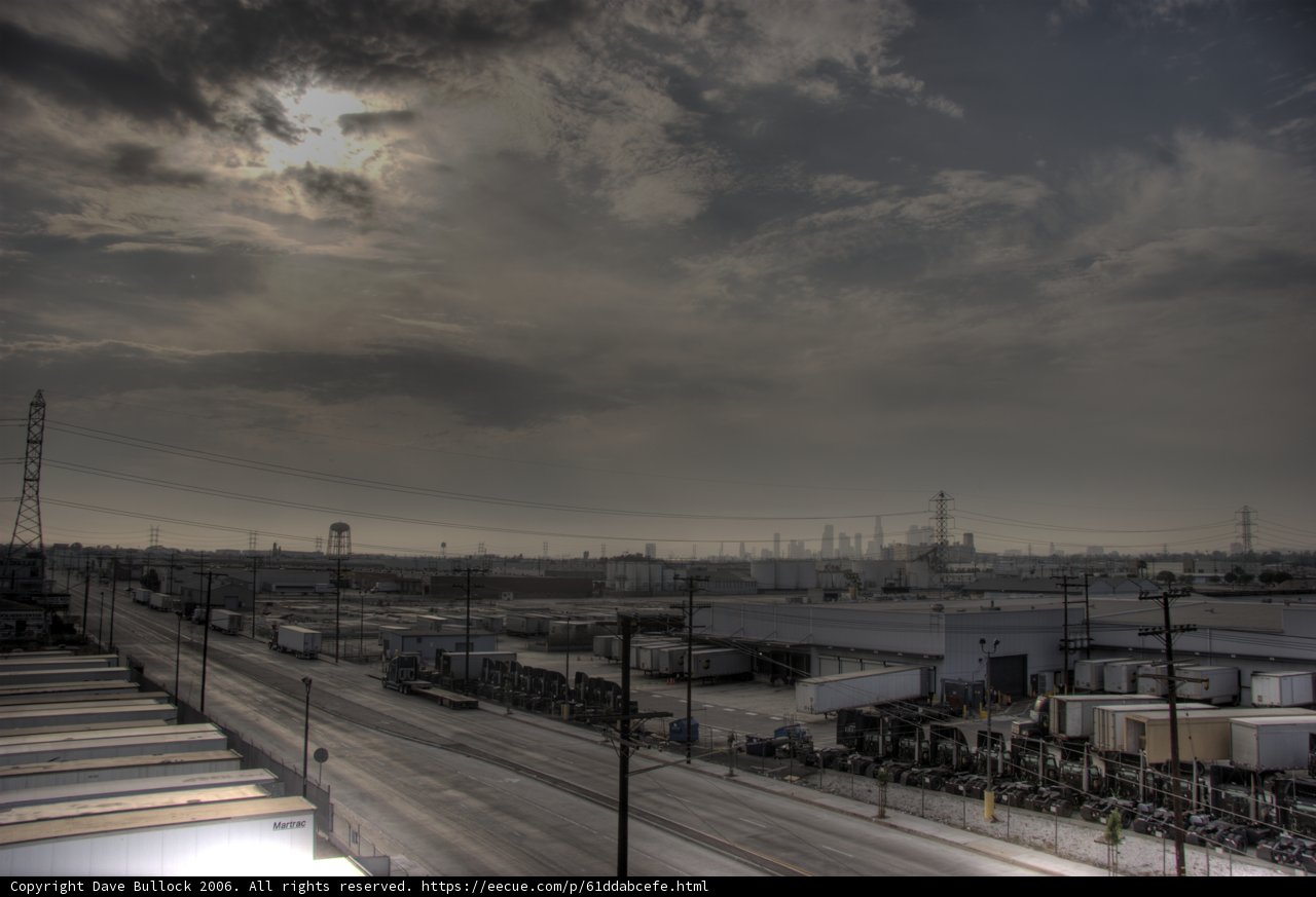 Sunlight Peeking Through Cloudy Skies over Busy Freeway