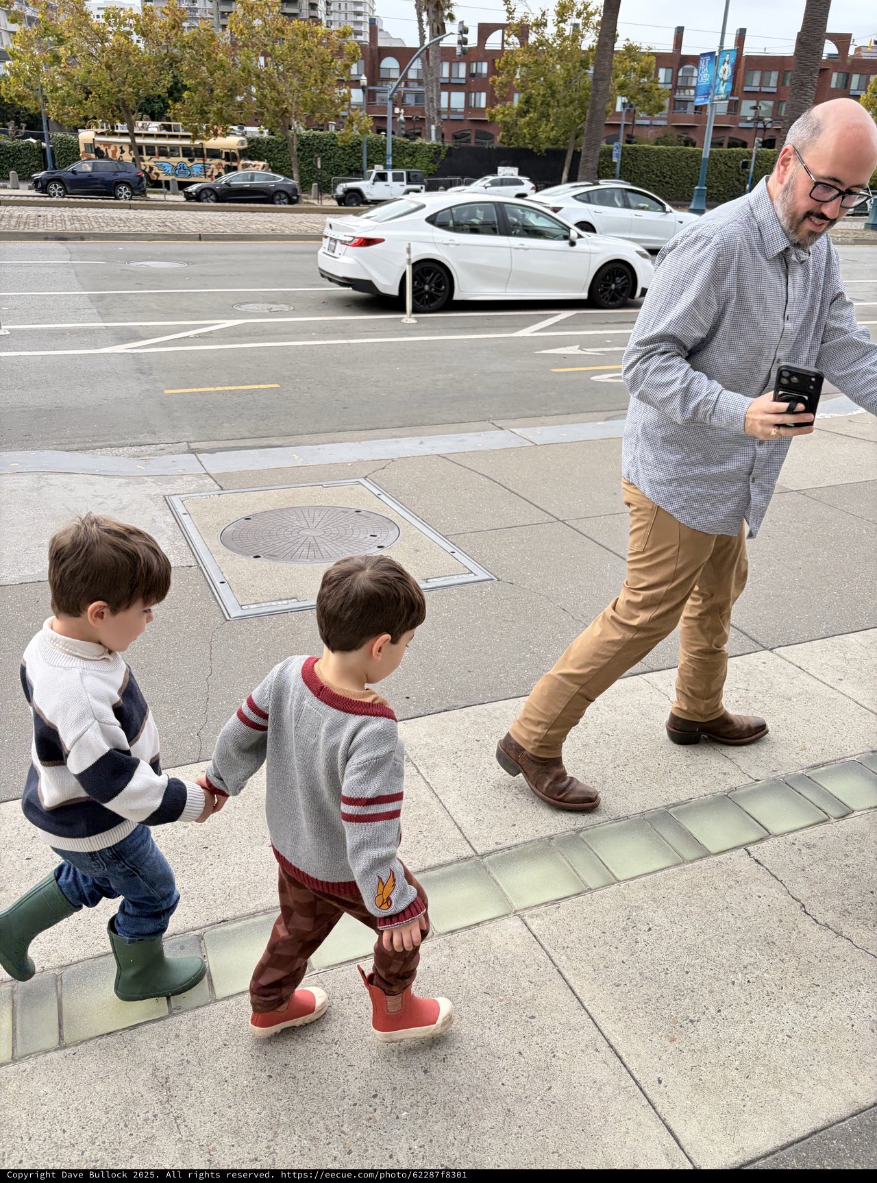 Father and Sons Walking Through Urban Sidewalk