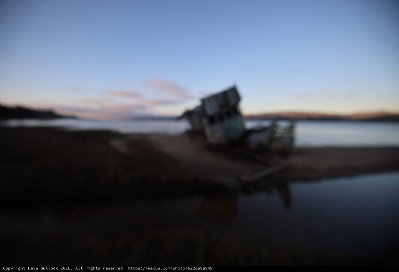 Shipwreck at Twilight on Coastal Beach