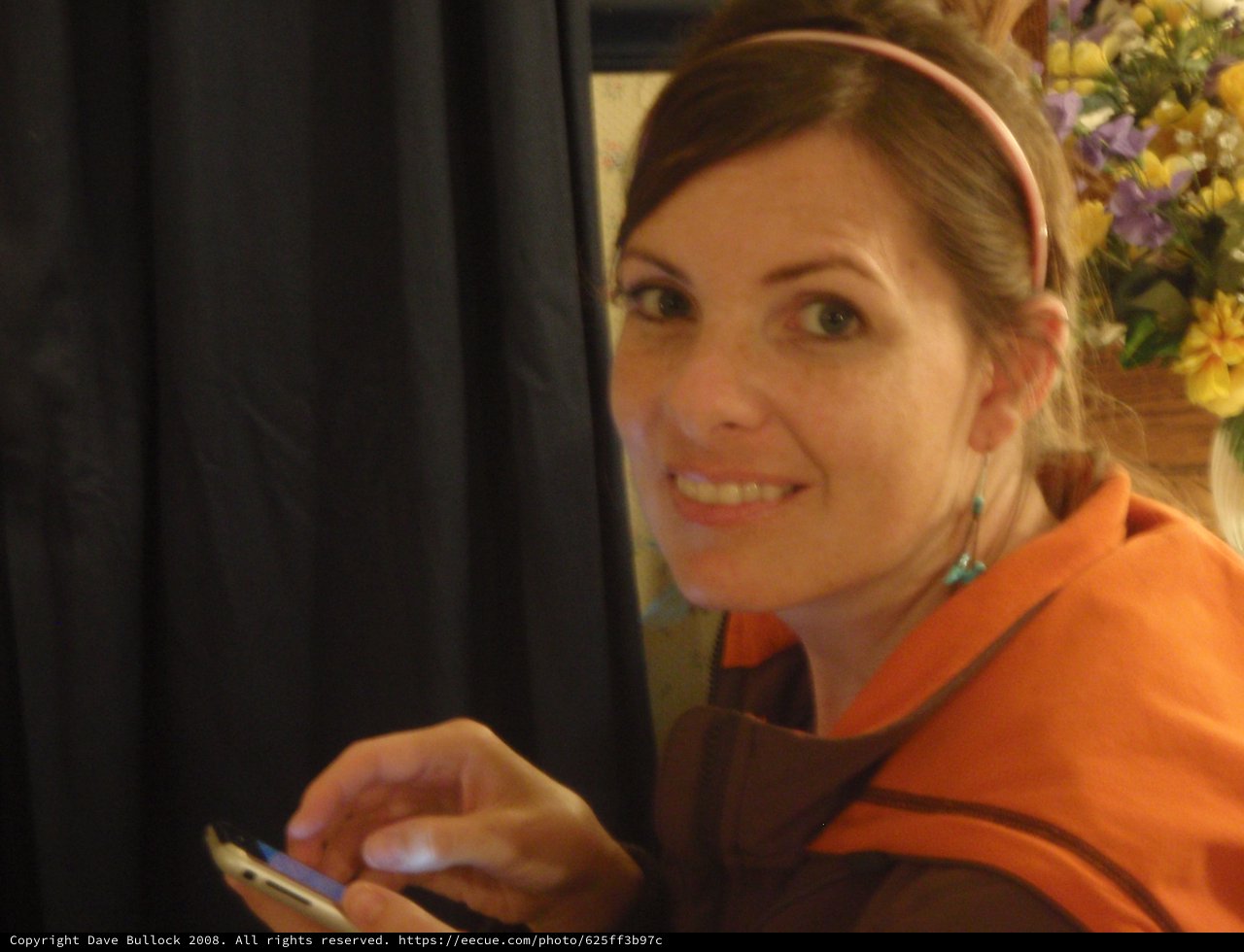 Woman Smiling with Phone at Wedding Reception