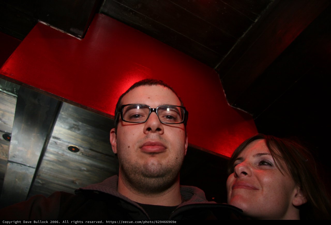 Low-Angle Nightclub Portrait Under Red Lighting