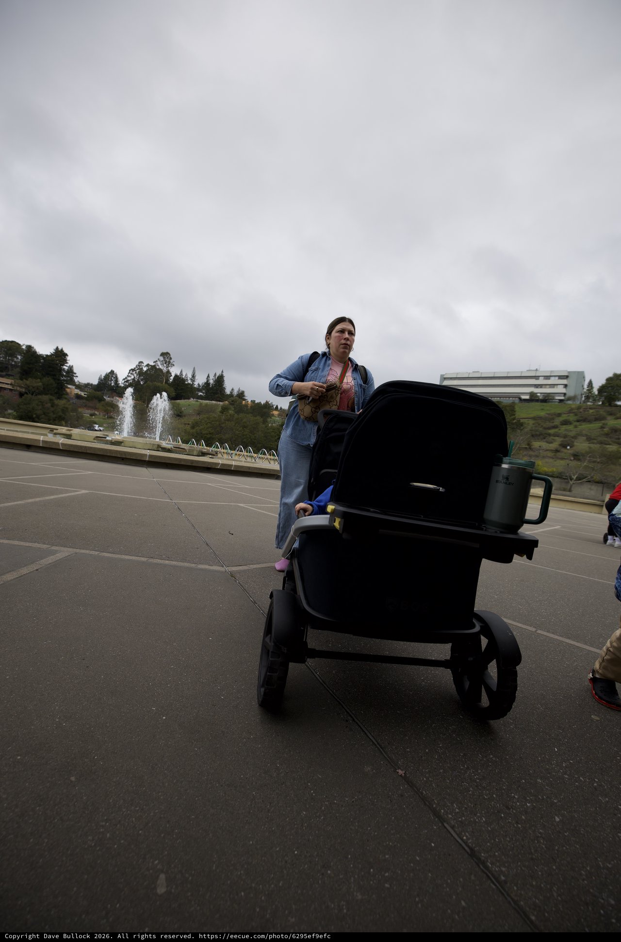Woman with Baby Stroller in Cloudy Park Plaza