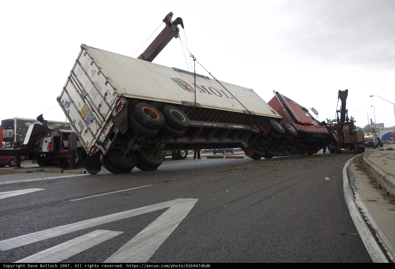Crane Lifts Overturned Truck from Tarmac