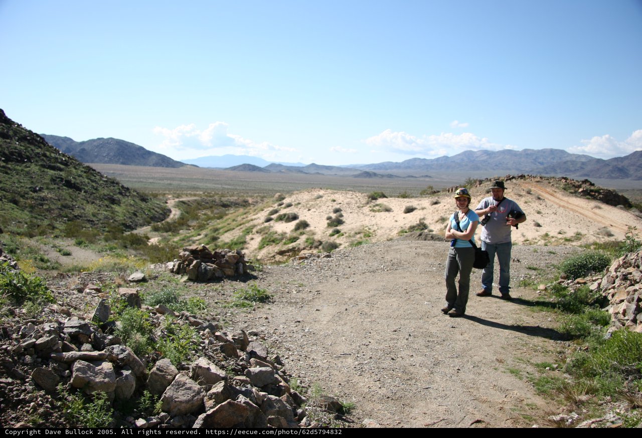 Two Hikers Pause on Desert Trail with Mountain Vista