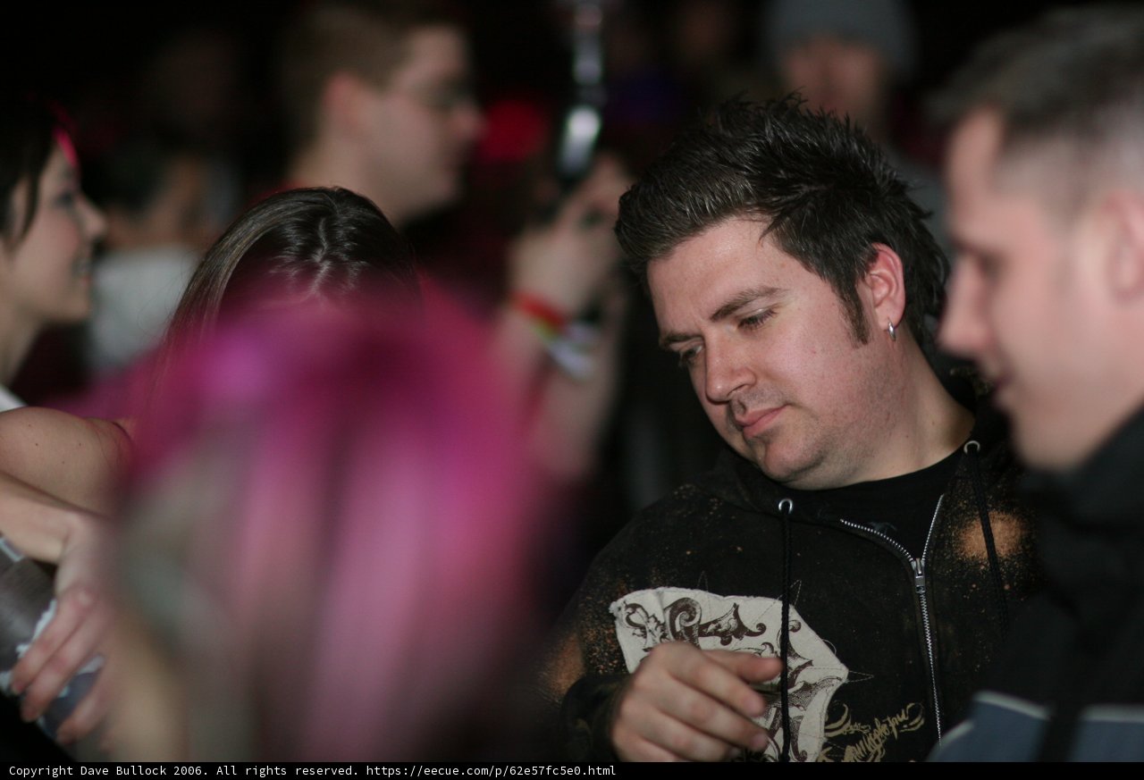 Pink-Haired Man Stands Out in Urban Nightlife Crowd