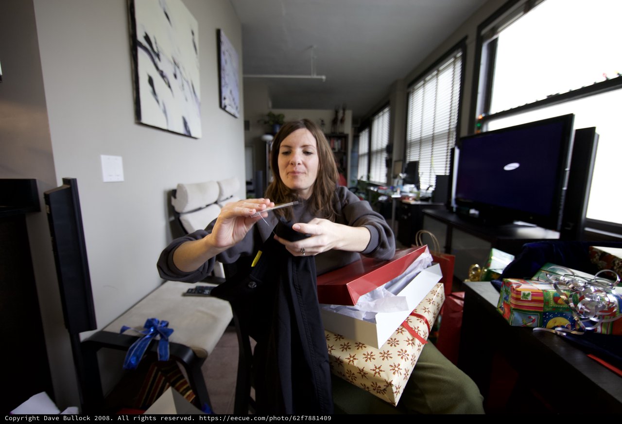 Woman Unwrapping Christmas Gifts in Modern Apartment
