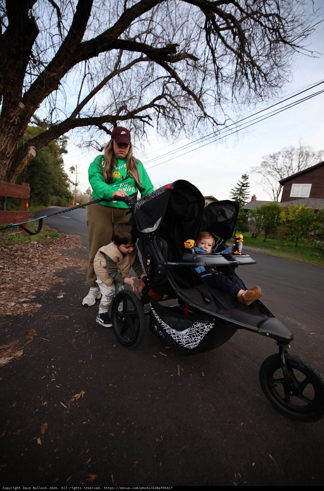 Mother with Two Young Children in Double Stroller on Winter Walk