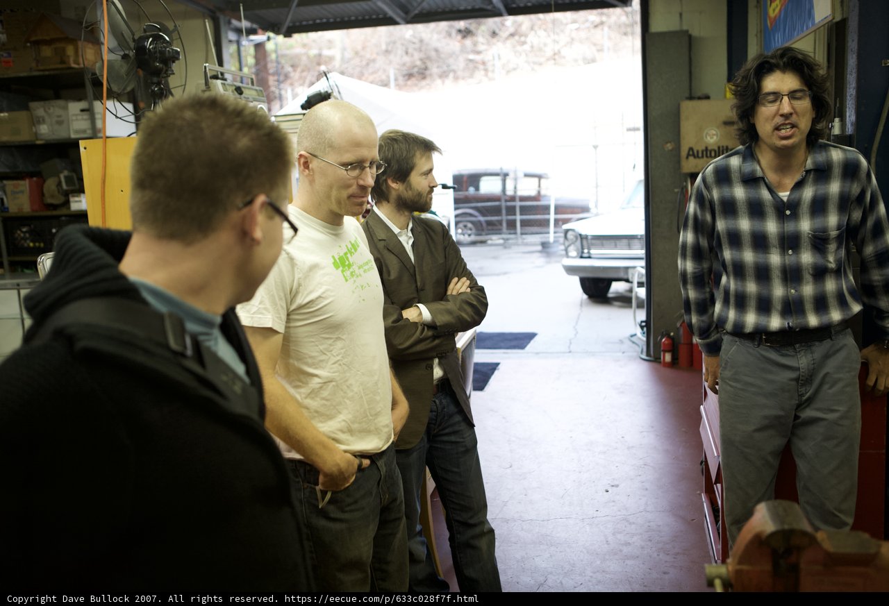 Group of Men Examining Plywood on Shelf