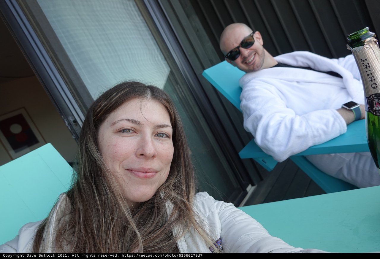 Couple Relaxing on Turquoise Pool Lounge Chairs