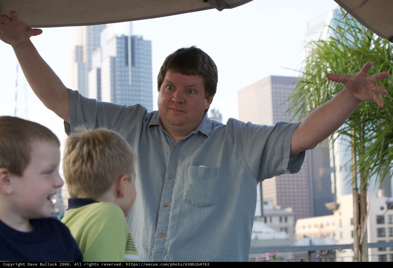 Man Gestures Dramatically with Kids in City