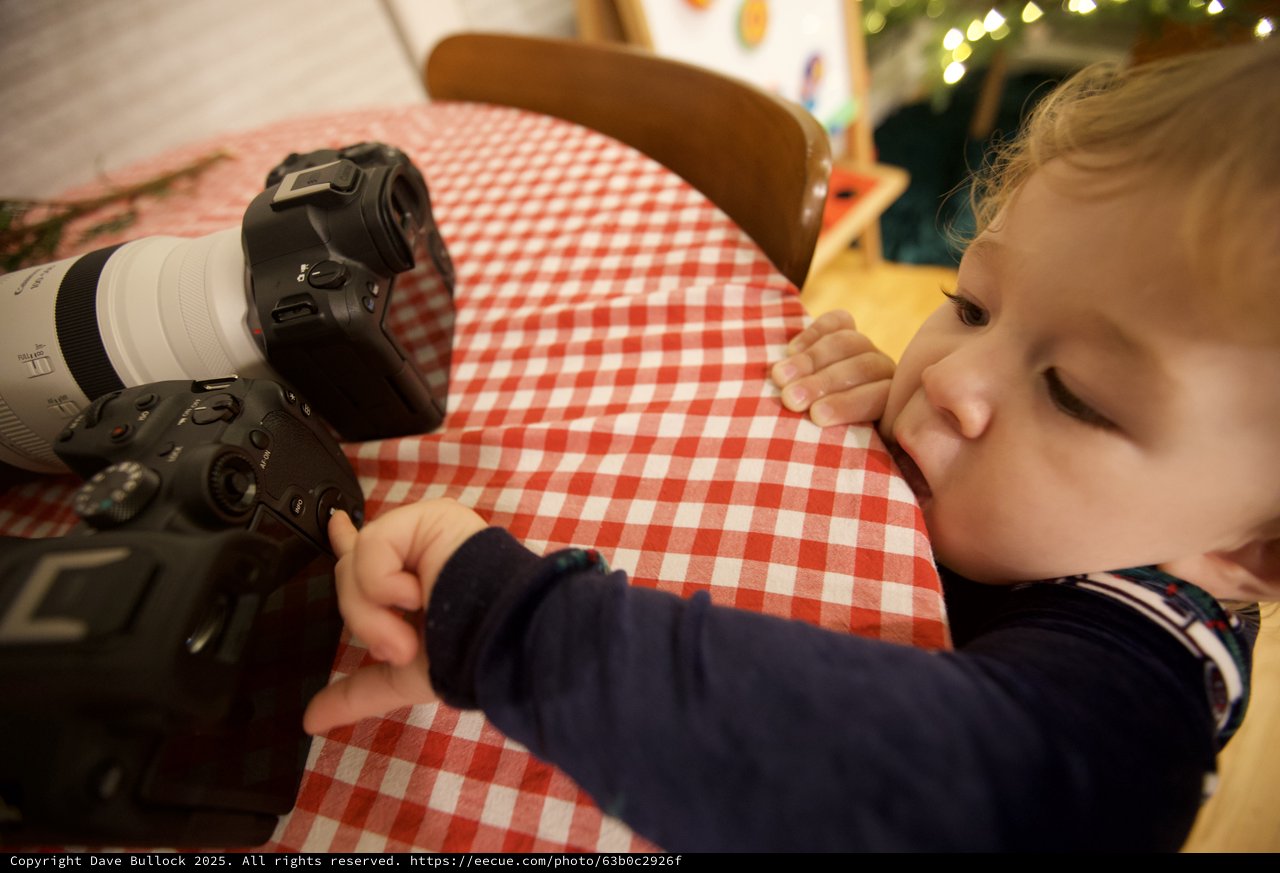 Curious Toddler Exploring Professional Camera Equipment