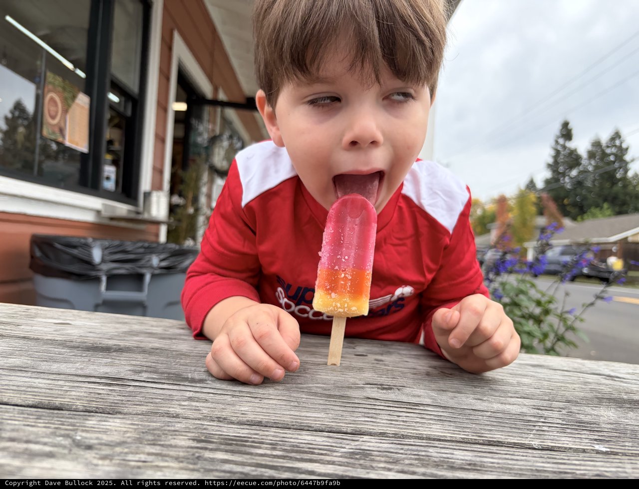 Pure Joy: Child Enjoying a Colorful Popsicle Outdoors