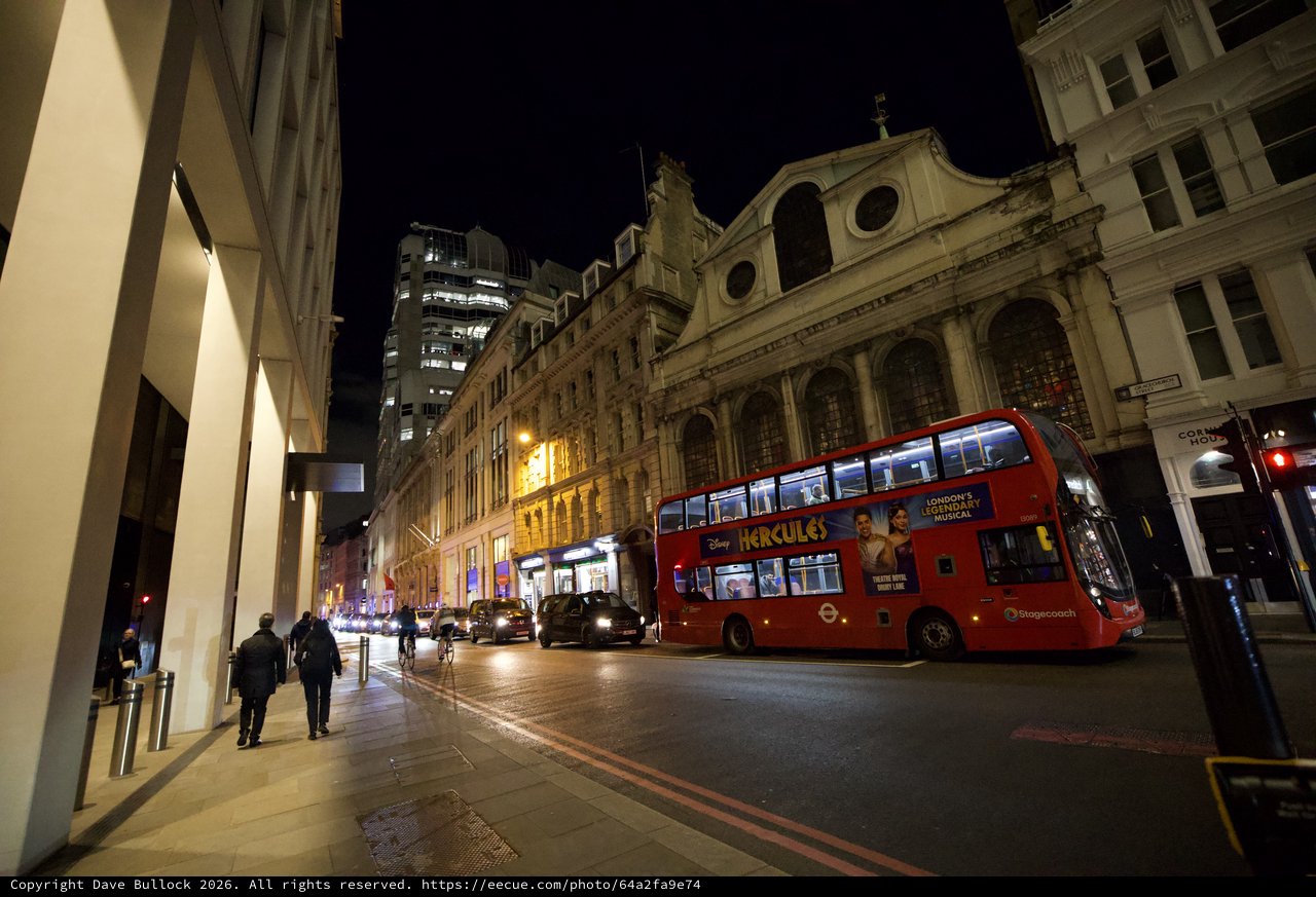 Red Double-Decker Bus on London Street at Night