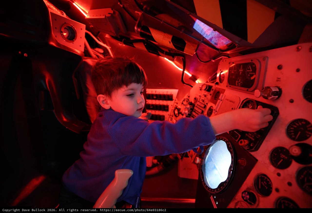 Child Exploring Spacecraft Interior at Space Center