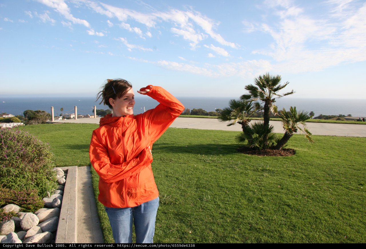 Woman in Orange Jacket Gazing at Ocean View