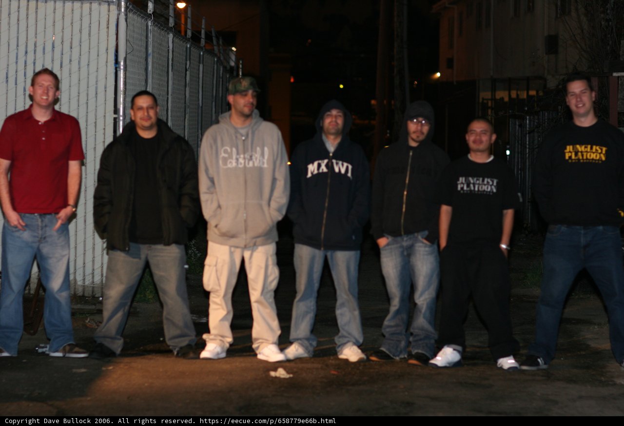 Group of Young Men Pose in Front of Fence