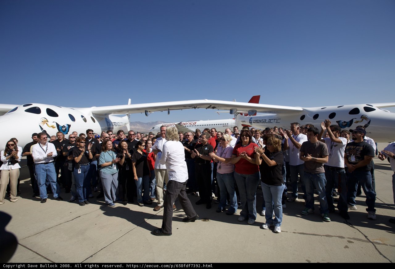 A Group of People Stand around a Small Airplane