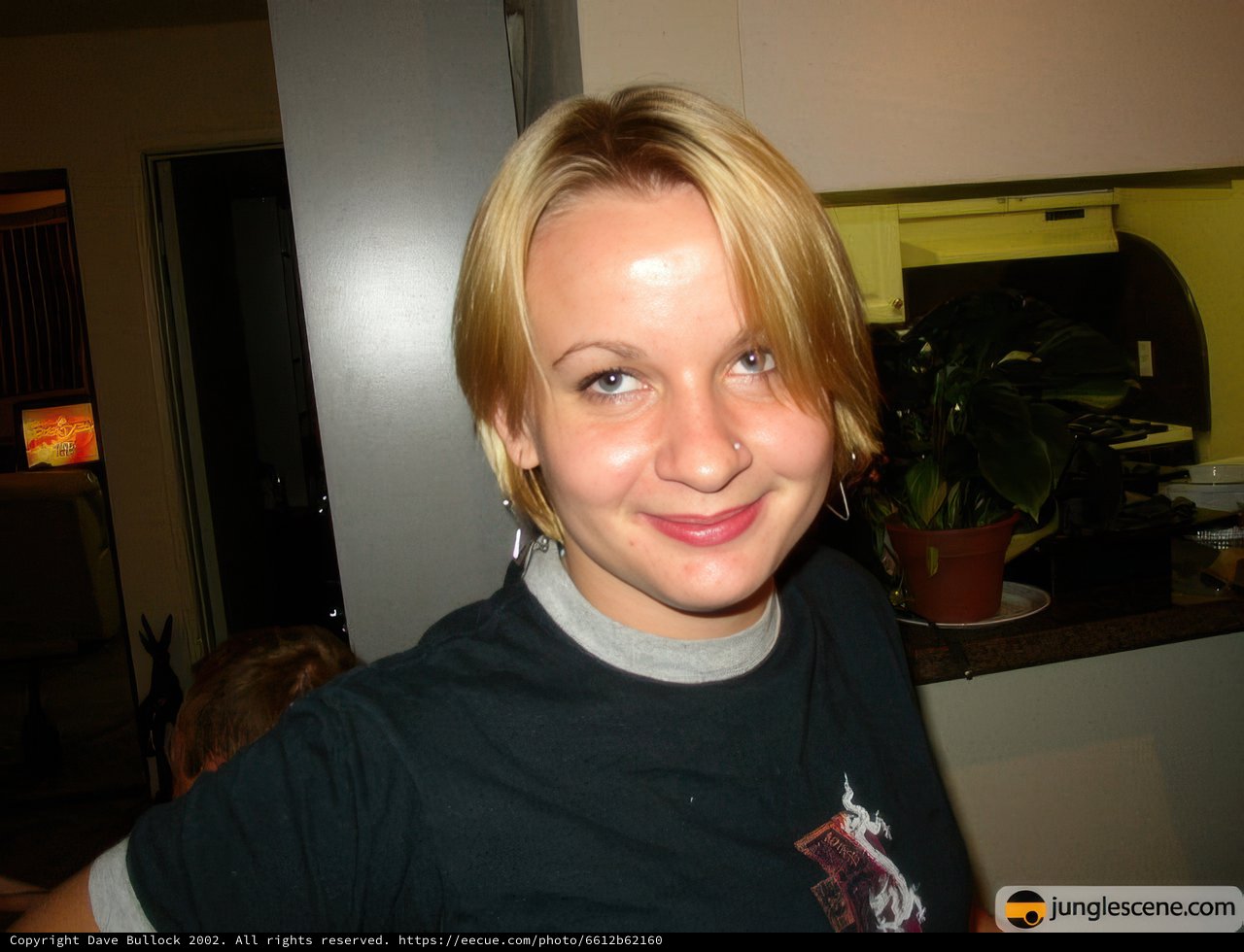 Blonde Woman Smiling Next To Potted Plant