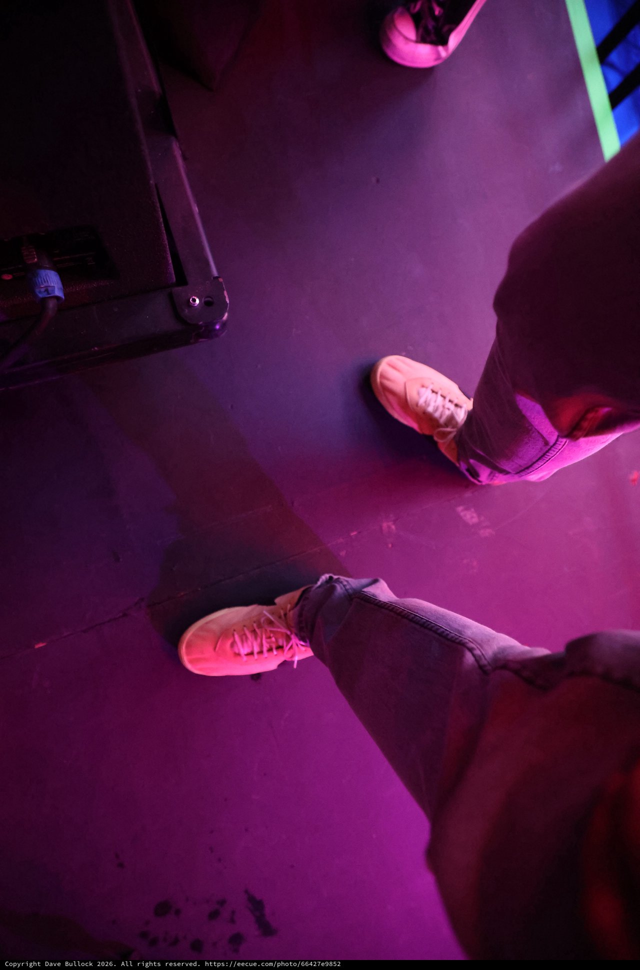 Neon Pink Sneakers on a Dark Festival Stage Floor