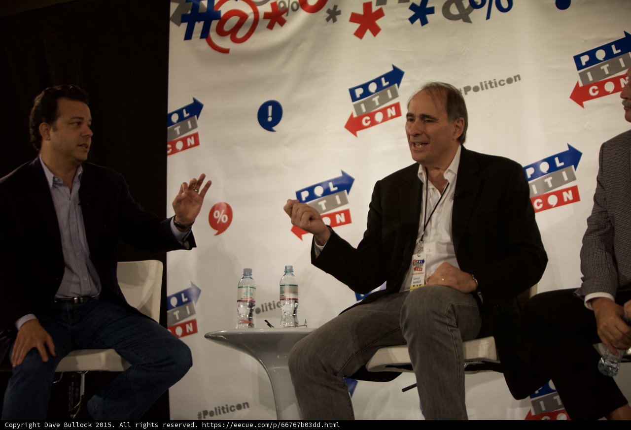 Three Men Engaging in Political Conversation on Stage