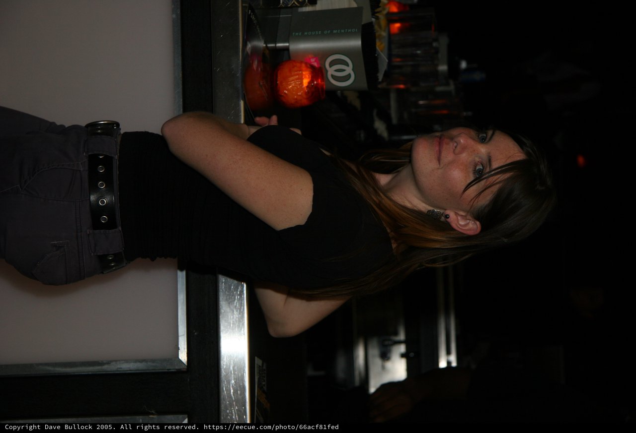 Woman at Bar Counter in Dim Nightclub Light