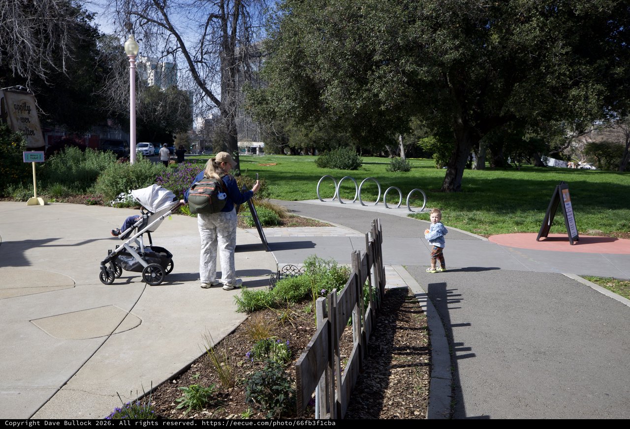 Young Family Explores Sunny Urban Park Pathway