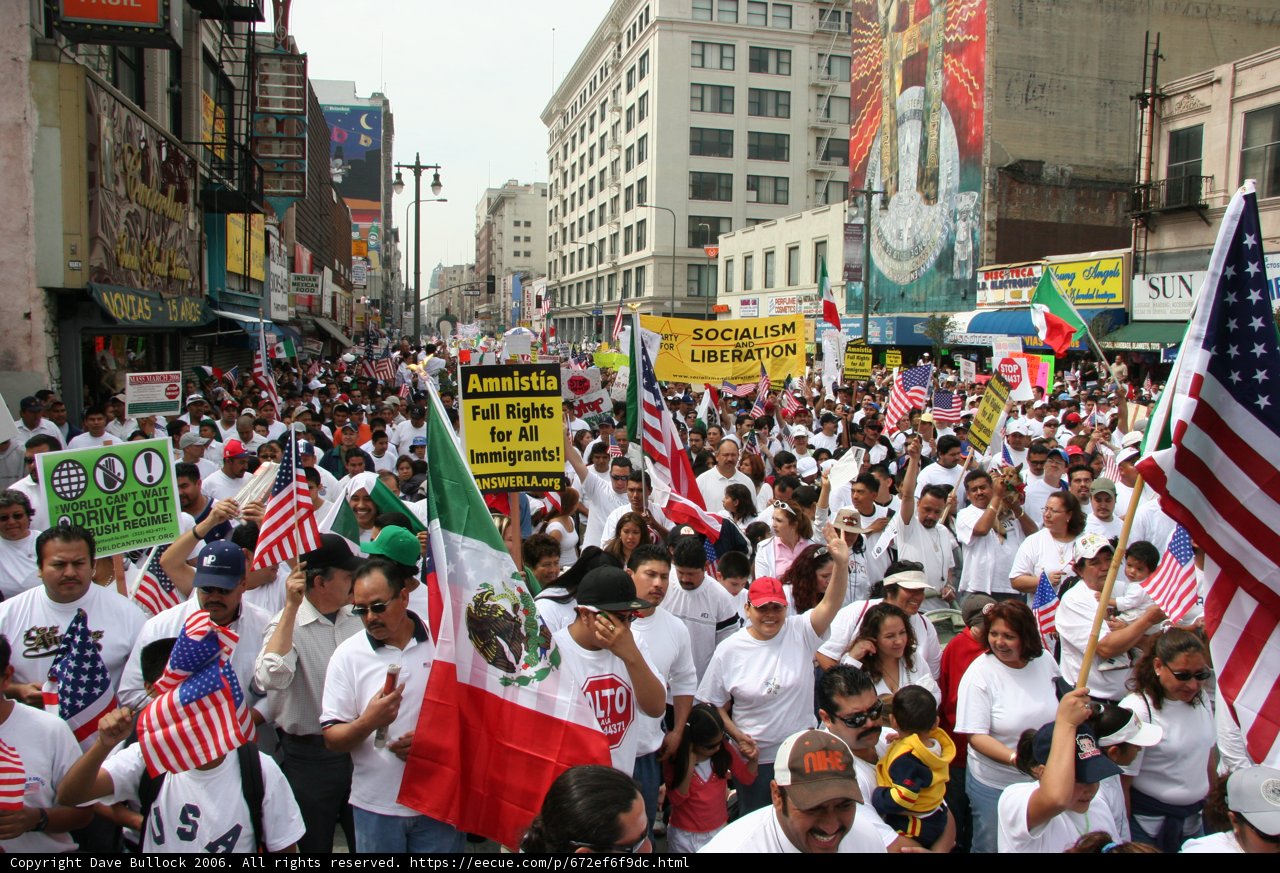 March for Equality Captions: A large group of people march through the city, holding flags and signs advocating for equality. Michelle Malkin, Alberto Coyote, and Nancy Shukri can be seen among the 60-strong crowd.