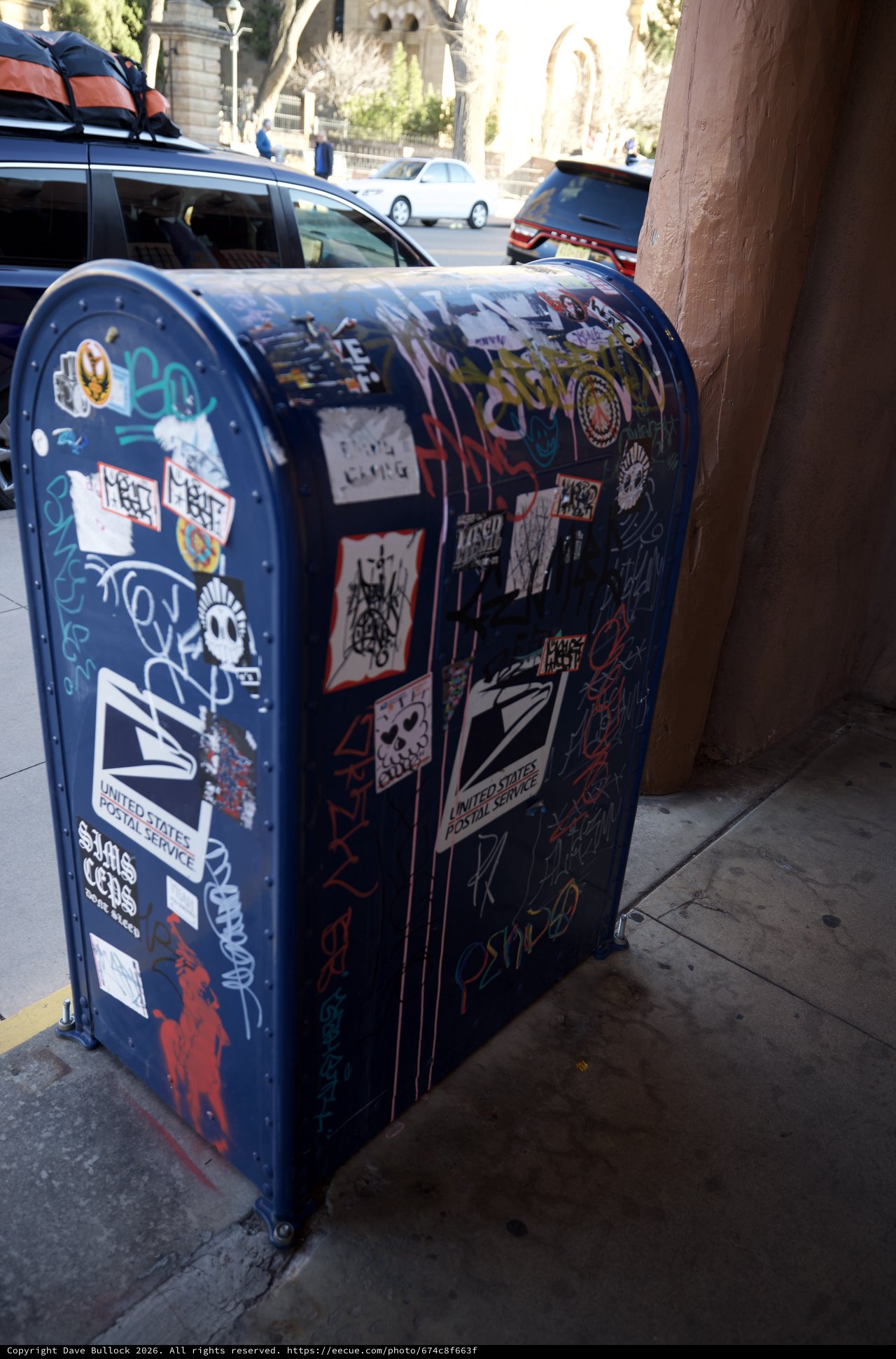 Street Art Sticker-Covered USPS Mailbox on Urban Corner