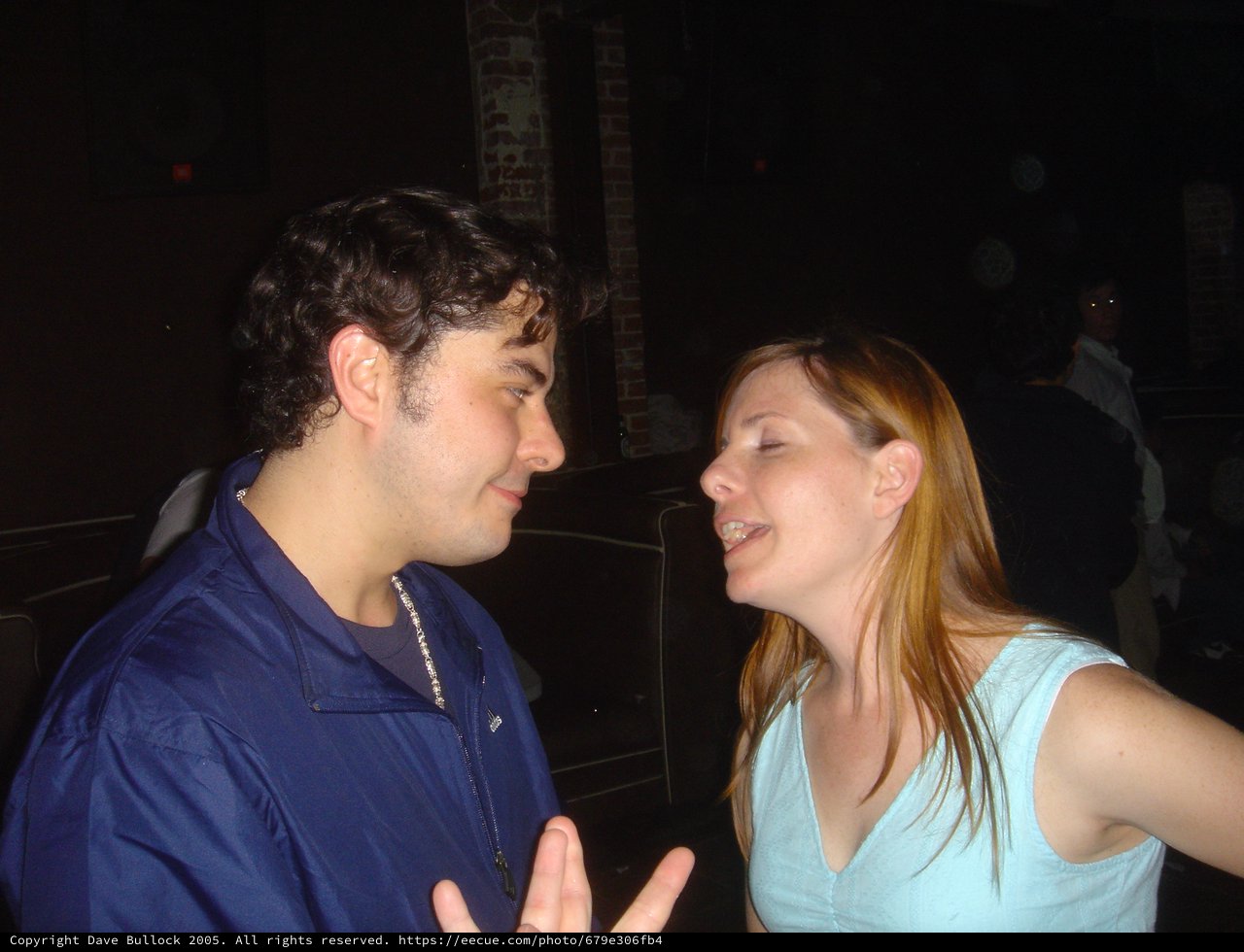 Two Friends in Animated Conversation at Nightclub
