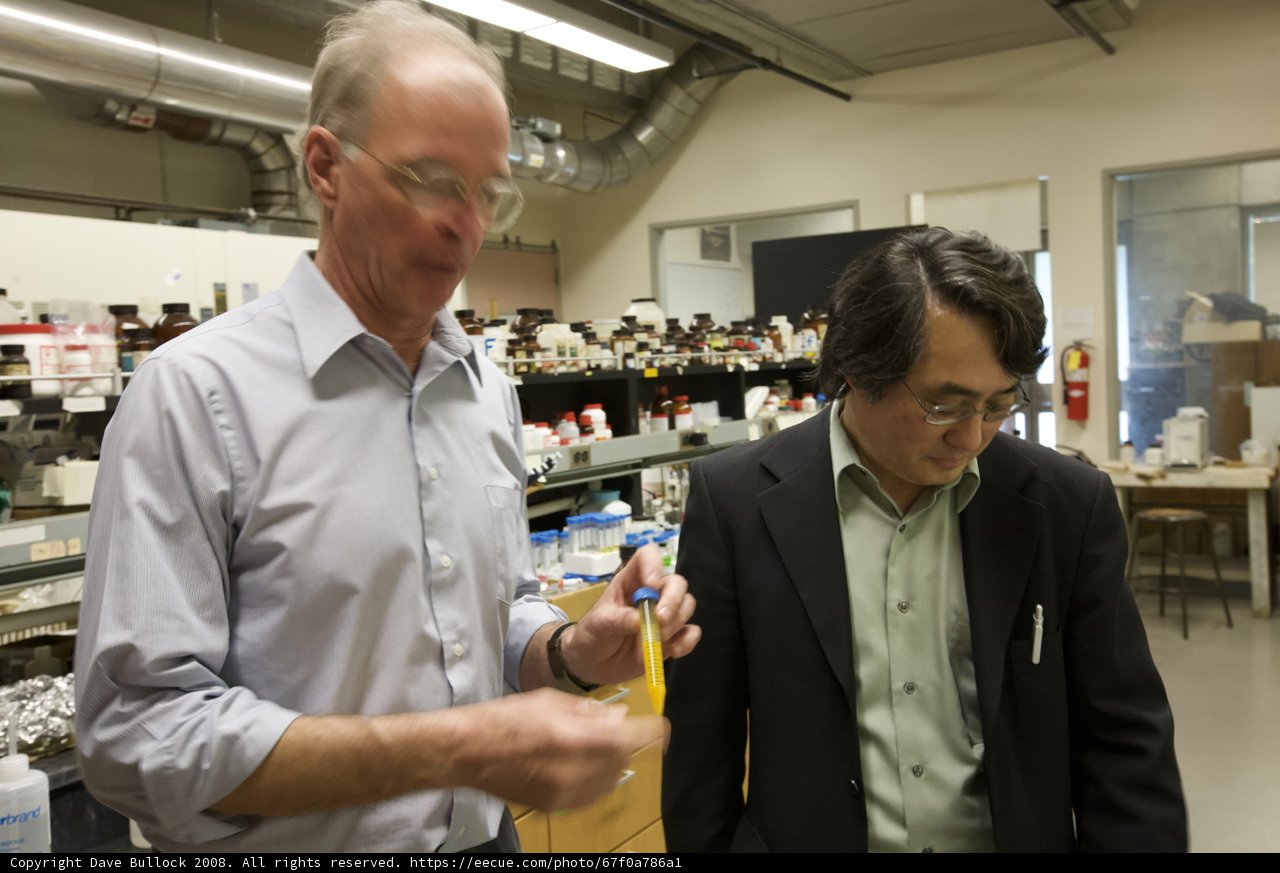 Two Men Conduct Experiment in Lab