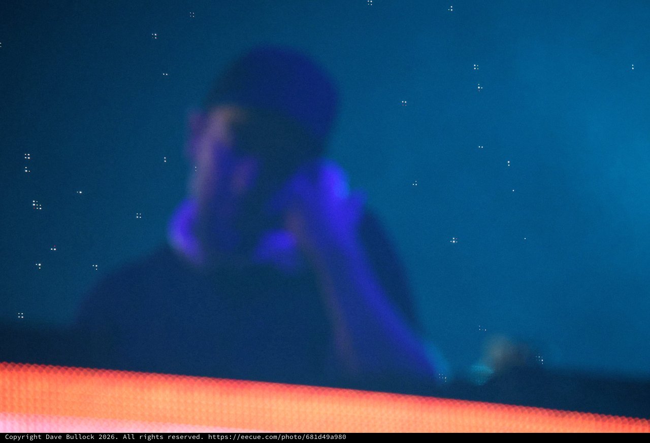 Silhouetted DJ Performs Under Electric Blue Stage Lights