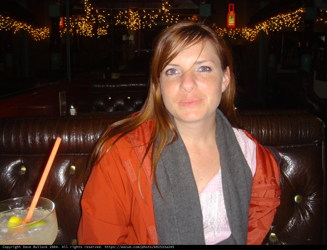 Woman Relaxing in Dimly Lit Bar Booth