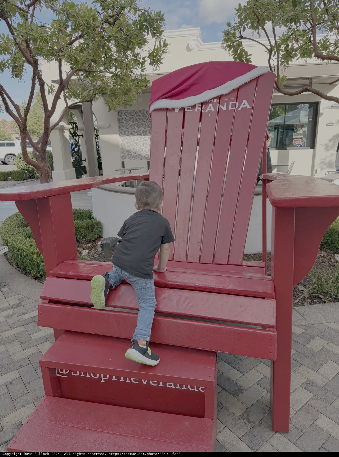 Child Playing on Giant Red Chair Installation