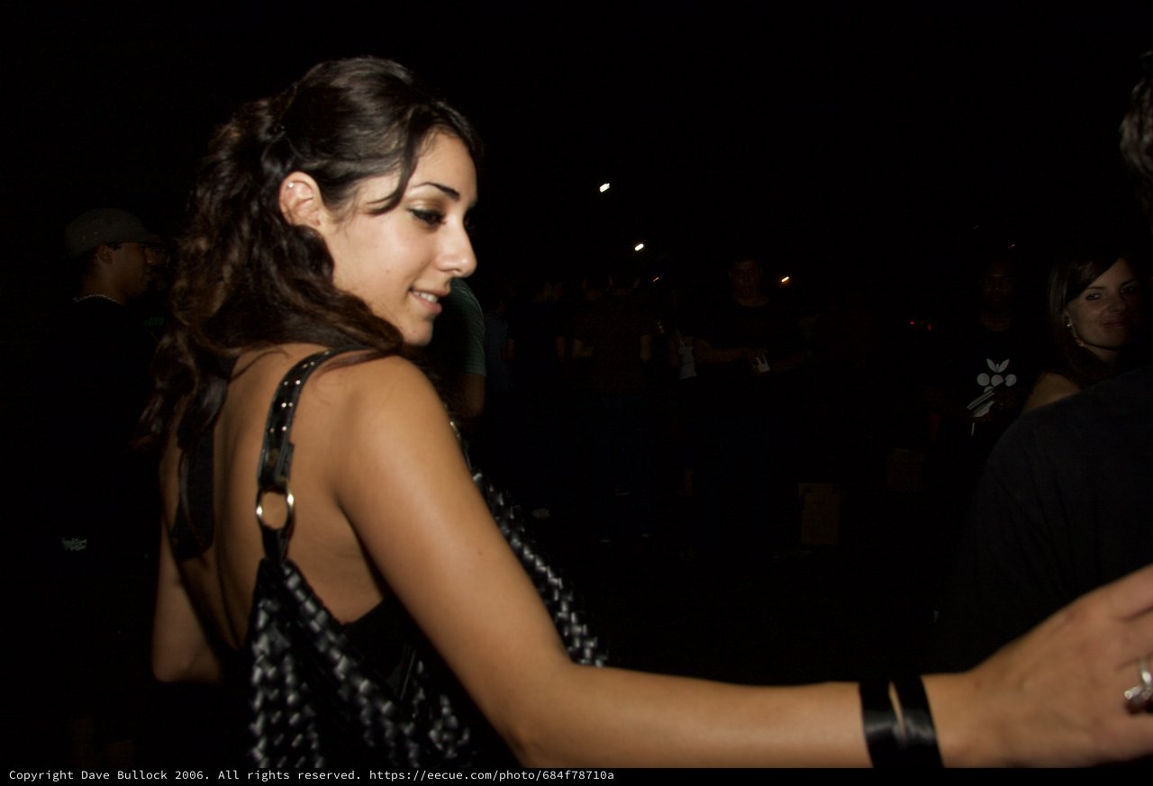 Young Woman Smiling at Nighttime Outdoor Gathering