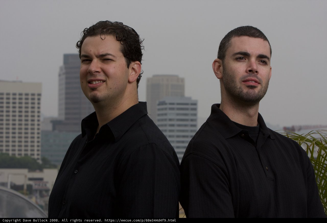 Two Happy Men in Black Shirts Standing in the City