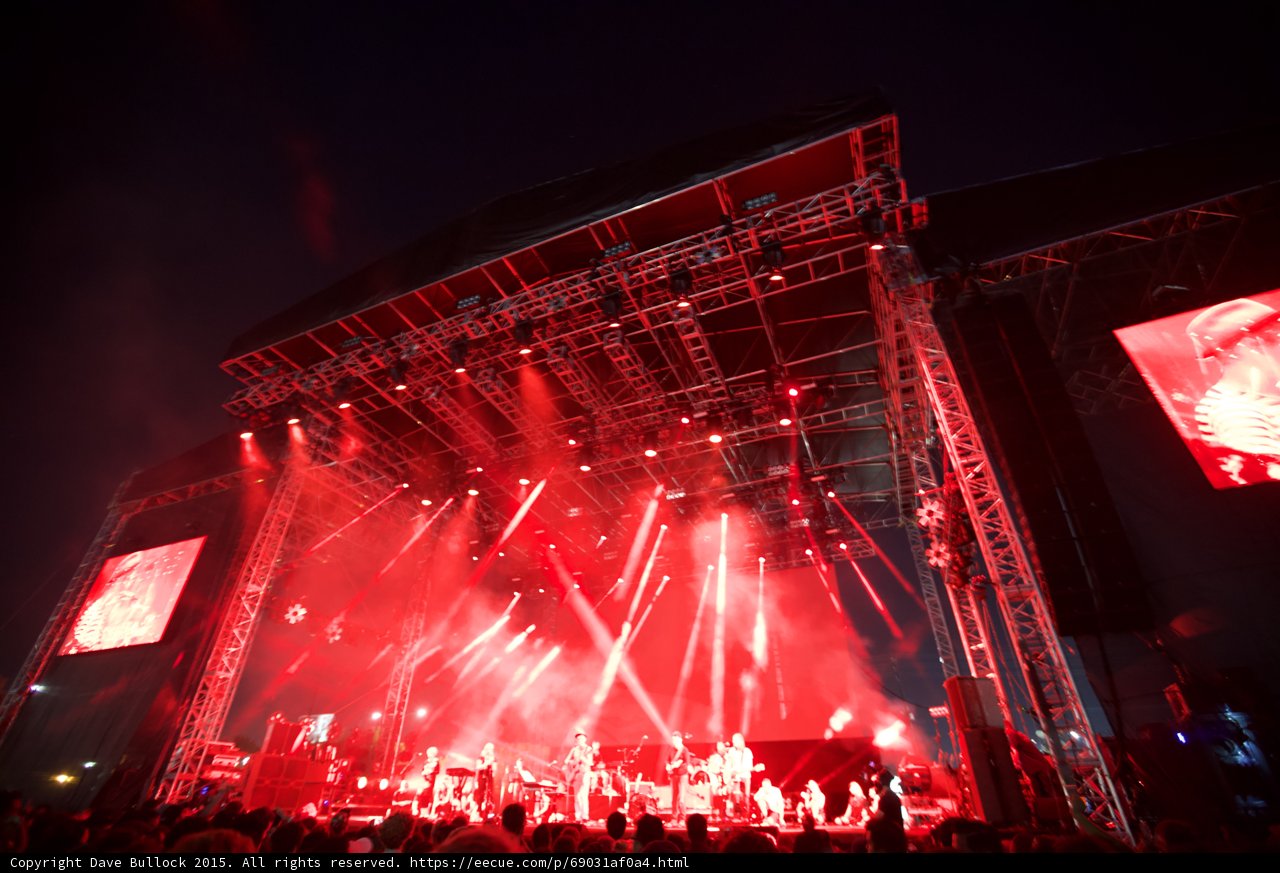 Belle and Sebastian Wide Stage Red Lighting Scaffolding Video Screens Spotlight Beams Night