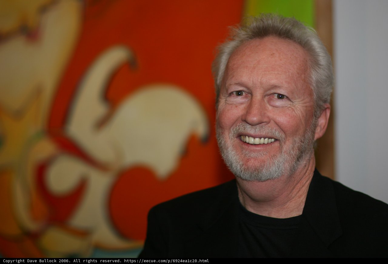 Happy Man Poses in Front of Vibrant painting
