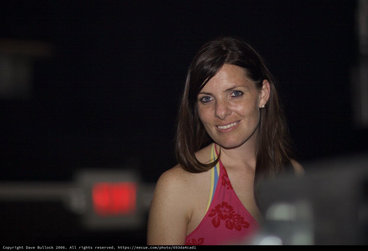 Smiling Woman at a Dimly Lit Evening Venue