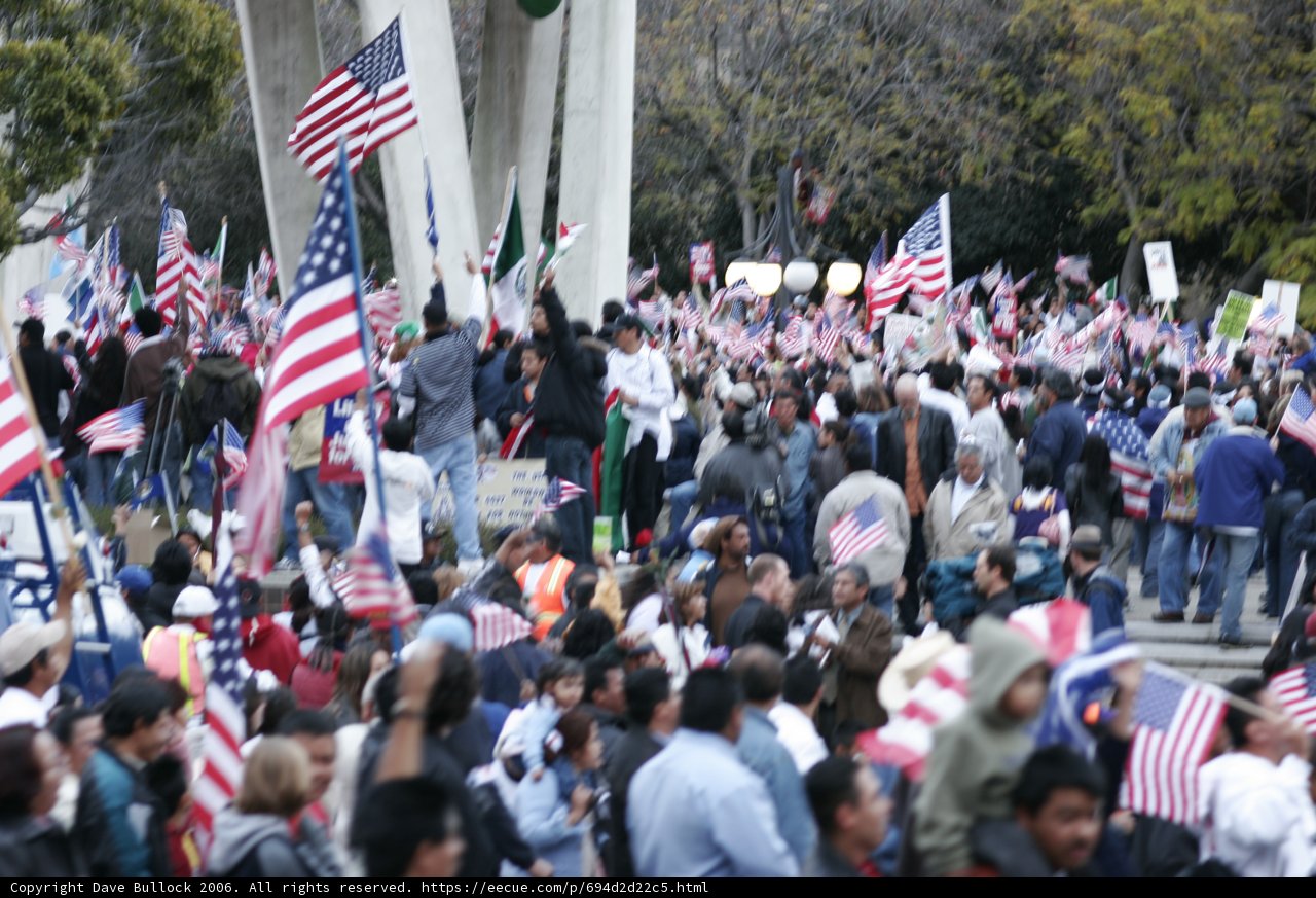 Patriotic crowd waves American flags