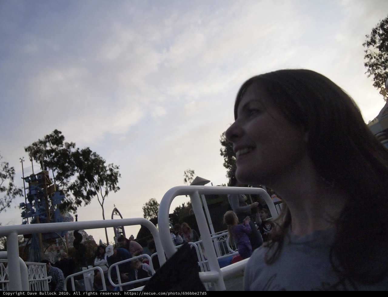 Woman Gazing Upward at Dusk in Theme Park