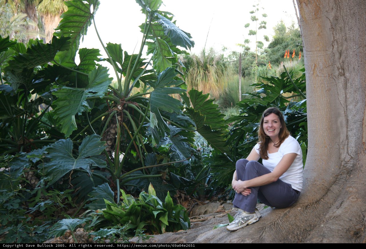 Young Woman Smiling Beside Tropical Garden Tree