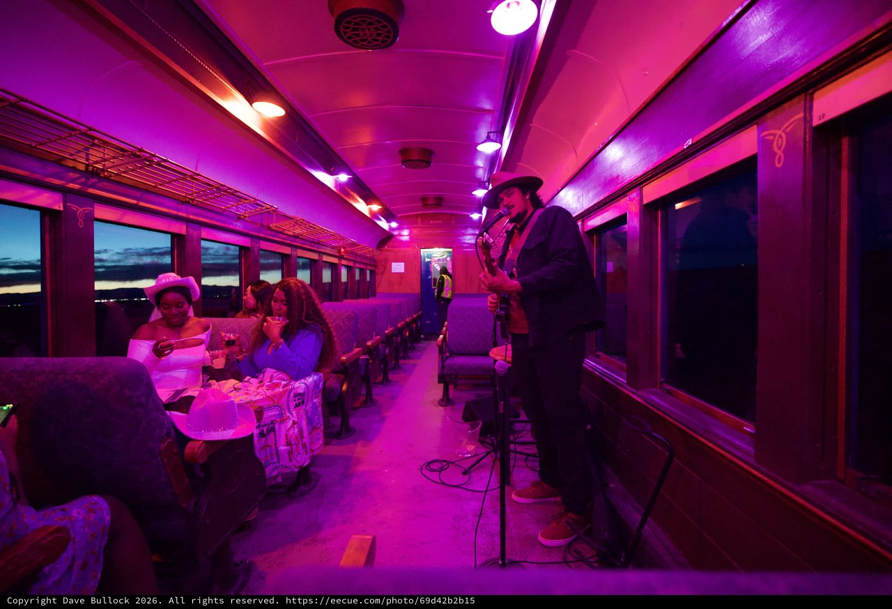 Purple-Lit Vintage Train Car Performance at Twilight